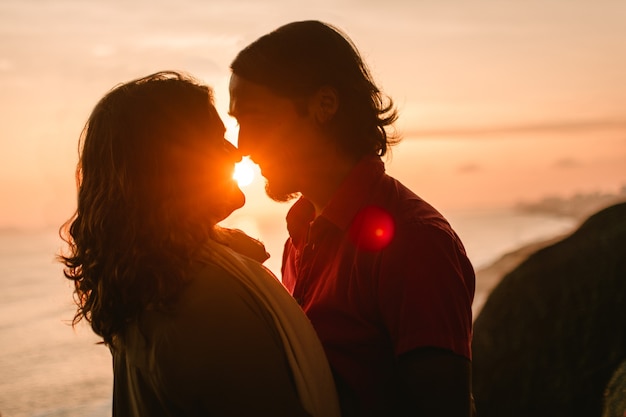 Portrait d'un couple d'homme et femme rétro-éclairé au coucher du soleil