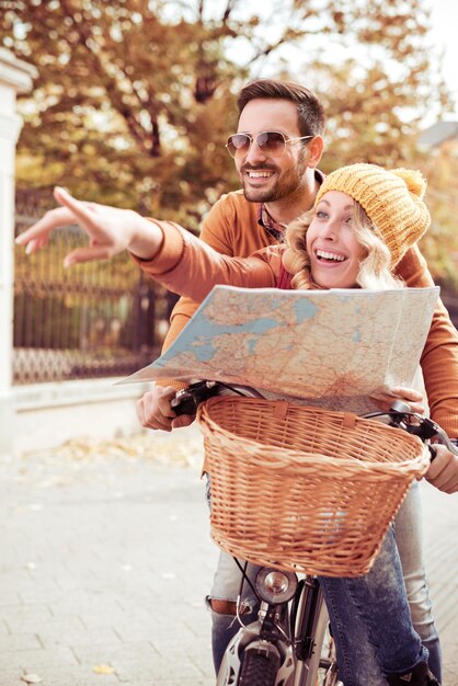 Portrait d'un couple joyeux de voyageurs avec carte dans la rue