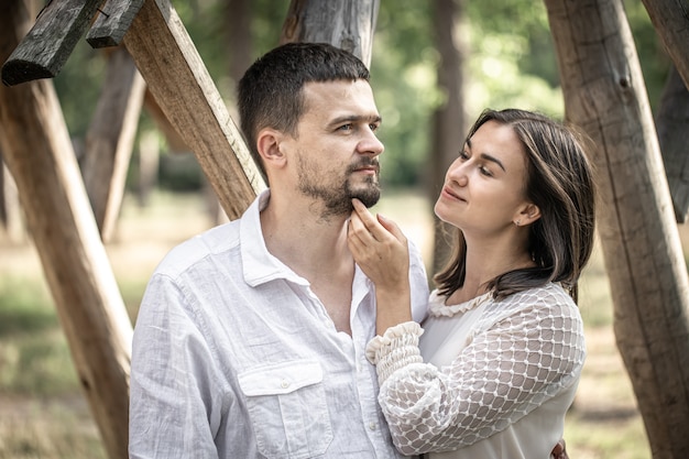 Portrait d'un couple marié heureux, d'un homme et d'une femme s'embrassant sur un arrière-plan flou dans la forêt.