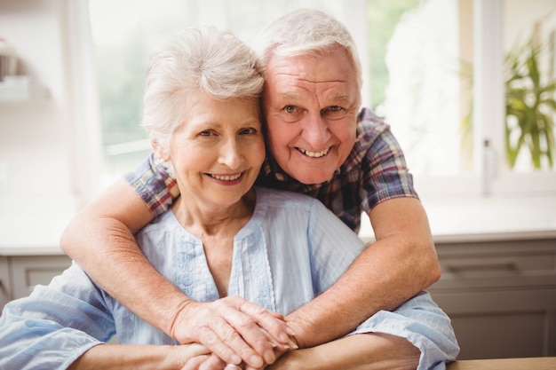 Portrait de couple de personnes âgées embrassant à la maison