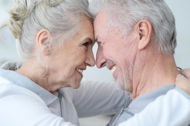 Portrait d'un couple de personnes âgées heureux debout embrassant