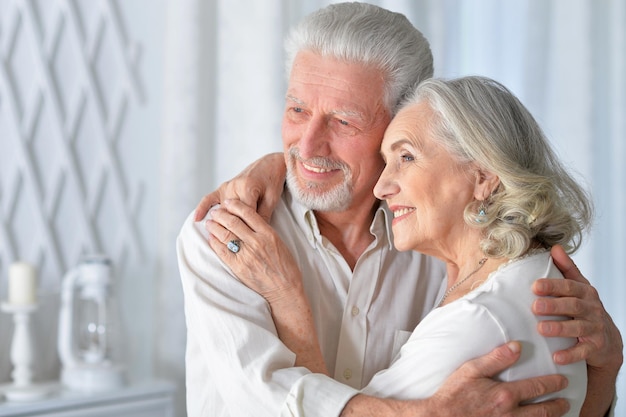 Portrait d&#39;un couple de personnes âgées heureux étreindre