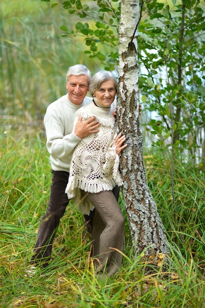 Portrait d'un couple de personnes âgées heureux posant dans la forêt d'automne