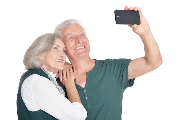 Portrait d'un couple de personnes âgées heureux prenant une photo de selfie sur fond blanc