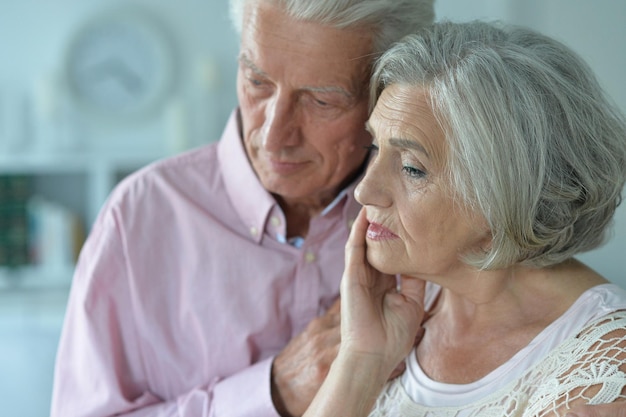 Portrait d'un couple de personnes âgées malheureux posant à la maison