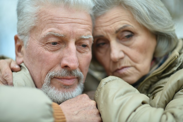 Portrait d'un couple de personnes âgées triste dans le parc d'automne