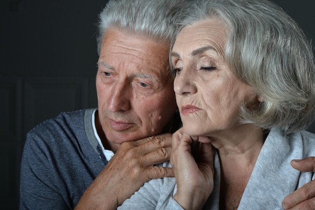 Portrait d'un couple de personnes âgées triste posant à la maison