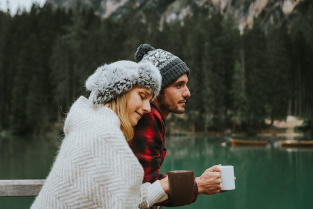 Portrait d'un couple romantique d'adultes visitant un lac alpin à Braies Italie