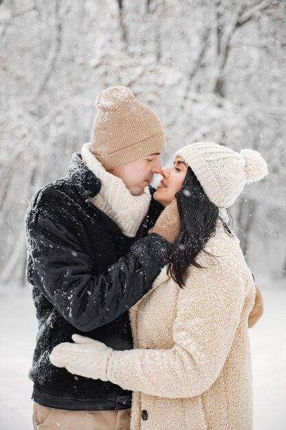 Portrait d'un couple romantique marchant dans la forêt le jour de l'hiver