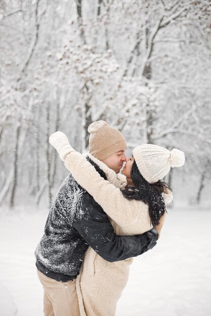 Portrait d'un couple romantique marchant dans la forêt le jour de l'hiver