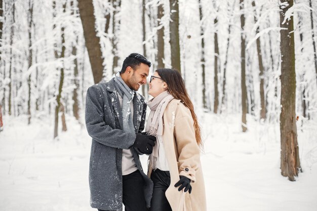 Portrait d'un couple romantique passant du temps ensemble dans la forêt d'hiver