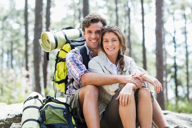 Portrait de couple souriant assis sur rocher