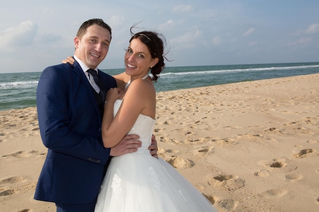 Portrait d'un couple souriant partageant un moment romantique à la plage