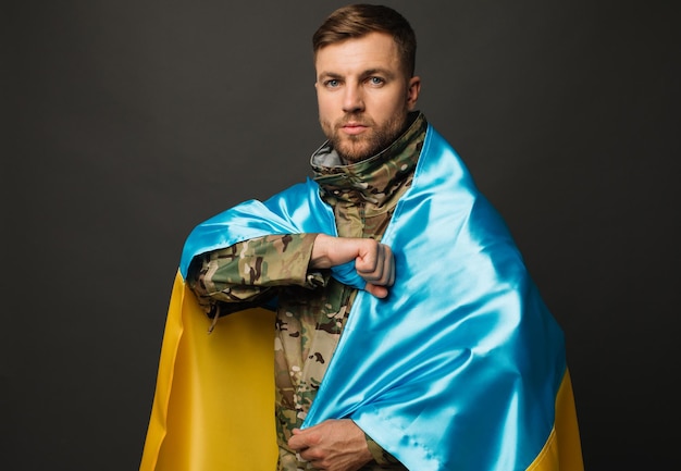 Portrait d'un courageux militaire ukrainien tenant le drapeau du concept de liberté de l'Ukraine