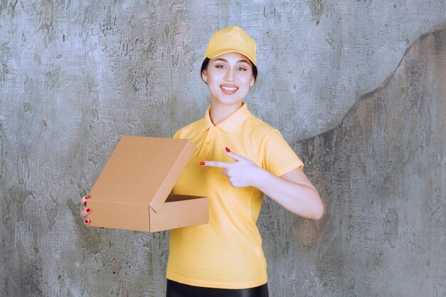 Portrait de courrier féminin pointant sur une boîte en carton