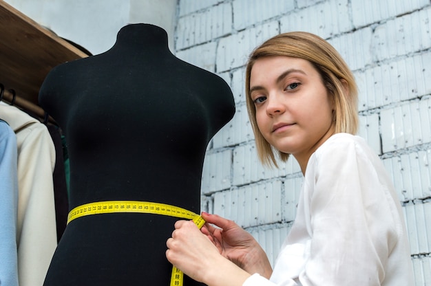 Photo portrait d'une couturière dans un gros plan de studio de couture. conception et création de vêtements.