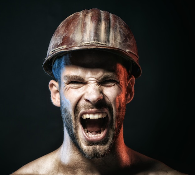 Portrait de crier barbu beau constructeur mâle agrandi portrait homme barbu avec casque de protection