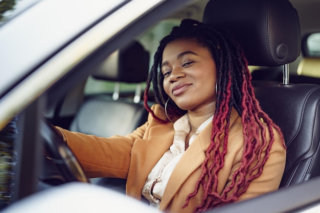 Portrait de dame afro-américaine positive à l'intérieur de la voiture