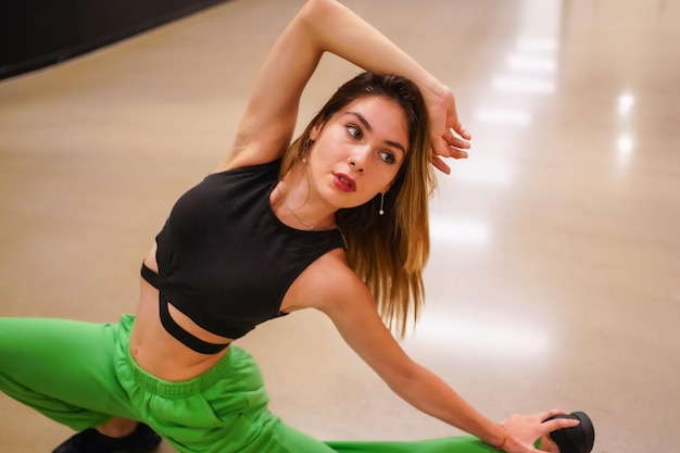 Portrait d'une danseuse de hip-hop urbaine à l'intérieur d'un bâtiment faisant des exercices d'étirement