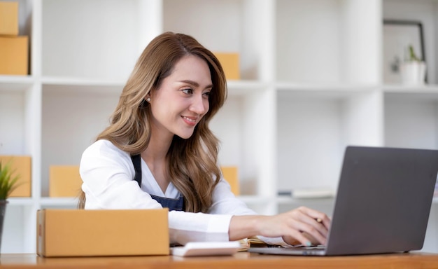 Portrait de démarrage de petites entreprises propriétaires de PME femmes entrepreneurs travaillant sur la boîte de réception et vérifier les commandes en ligne pour se préparer à emballer les boîtes vendre aux clients des idées d'affaires PME en ligne