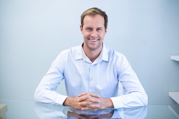 Portrait de dentiste heureux assis au bureau