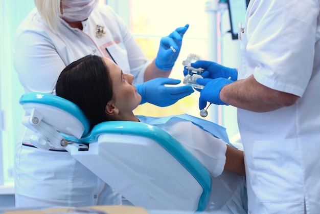 Portrait d'un dentiste qui traite les dents d'une jeune patiente