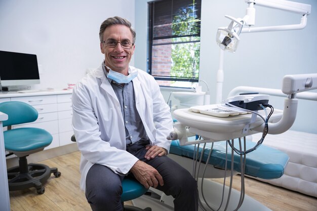 Portrait de dentiste souriant assis sur une chaise