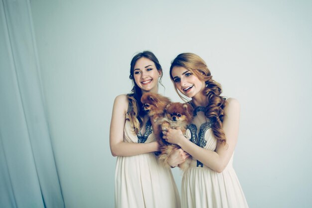 Portrait de deux belles filles avec leurs animaux de compagnie. mariage pour chiens