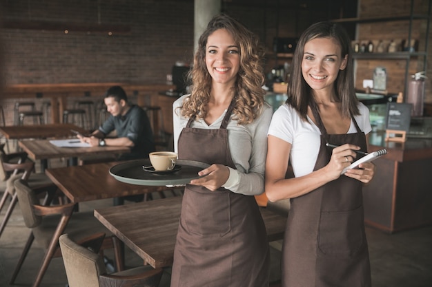 Portrait de deux belles serveuses souriant à la caméra