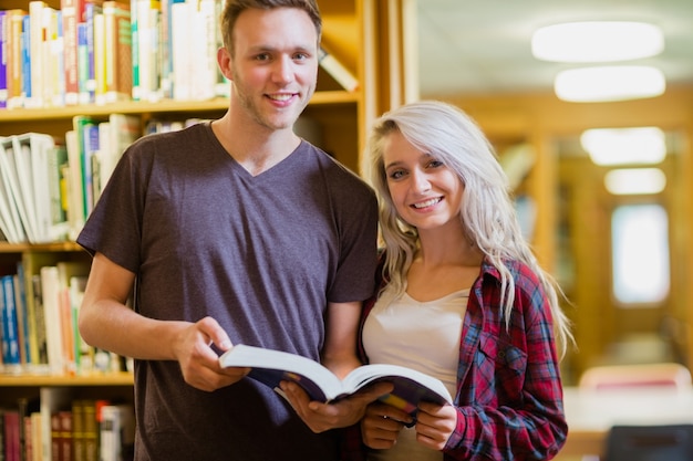 Portrait de deux étudiants lisant un livre dans la bibliothèque