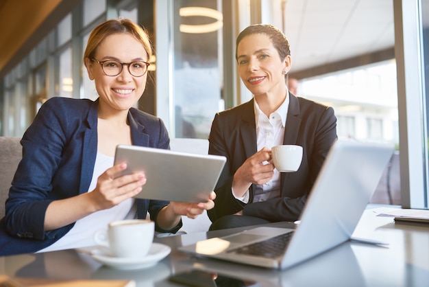 Portrait de deux femmes d'affaires buvant un café dans un café