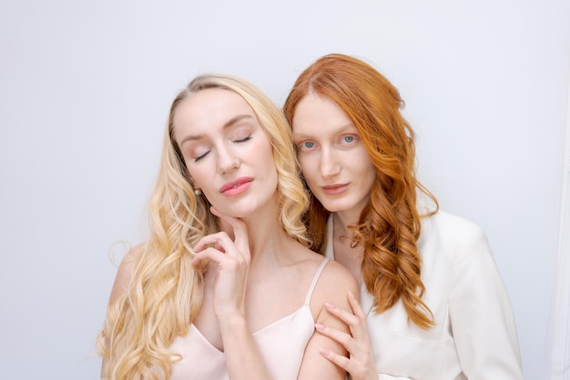 Portrait de deux femmes blondes et rousses gaies en été portant des vêtements souriants posant