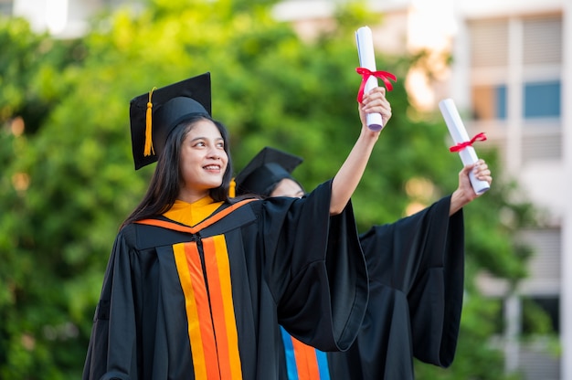 Portrait Deux femmes diplômées, diplômés universitaires titulaires d'un diplôme et sont heureux