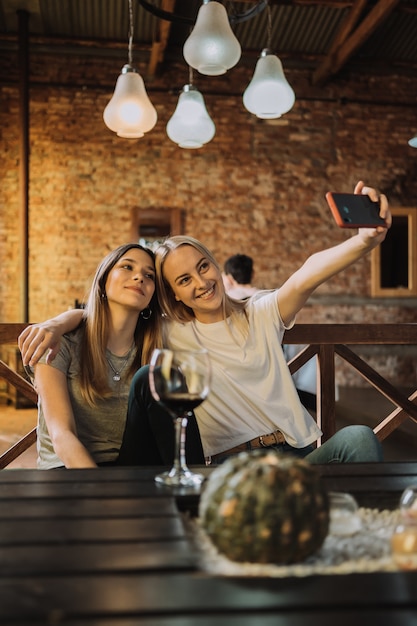 Portrait de deux femmes faisant un selfie dans le restaurant