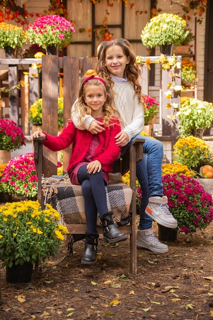 portrait de deux filles soeurs en automne près de la maison