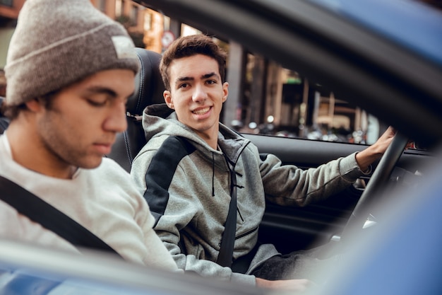 Portrait de deux gars assis dans une voiture de sport décapotable