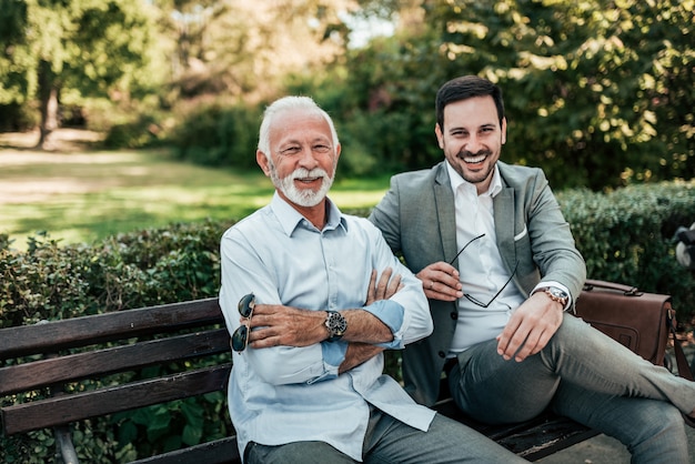 Portrait de deux hommes élégants assis sur un banc. Regardant la caméra.