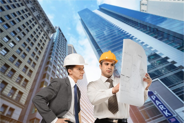 Portrait de deux ingénieurs avec plan sur fond