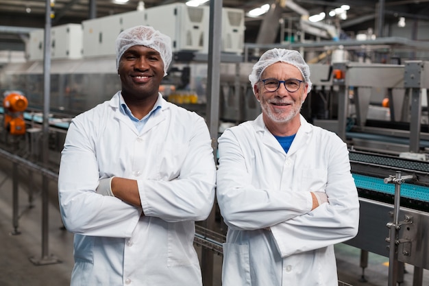 Portrait de deux ingénieurs d'usine debout avec les bras croisés