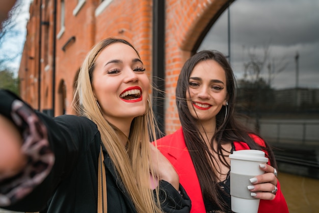 Portrait de deux jeunes amis prenant un selfie à l'extérieur dans la rue