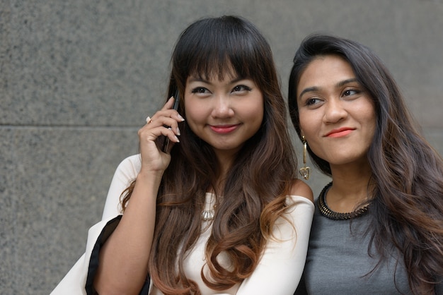 Portrait de deux jeunes femmes d'affaires asiatiques ensemble dans la ville en plein air