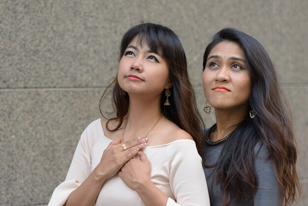 Portrait de deux jeunes femmes d'affaires asiatiques ensemble dans la ville en plein air