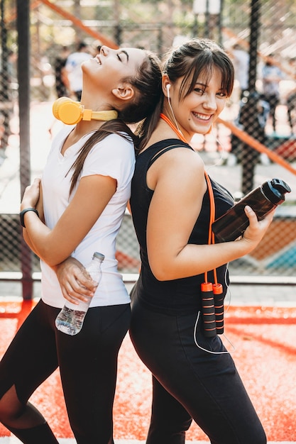 Photo portrait de deux jeunes femmes riant après avoir fait des exercices du matin