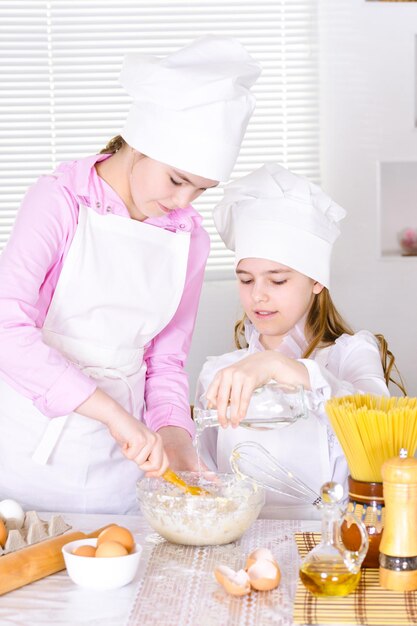 Portrait de deux jolies filles en toque de chef cuisine