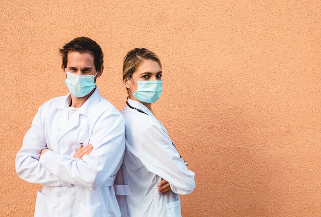 Portrait de deux médecins avec masque de protection. Fond coloré