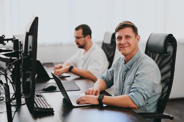 Portrait de deux programmeurs professionnels masculins travaillant sur ordinateur dans divers bureaux Technologies informatiques modernes Développement d'applications de programmes d'intelligence artificielle et concept de jeux vidéo