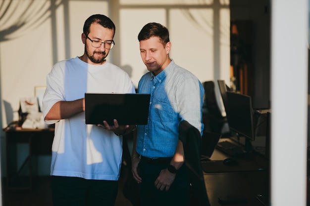 Portrait de deux programmeurs professionnels masculins travaillant sur ordinateur dans divers bureaux Technologies informatiques modernes Développement d'applications de programmes d'intelligence artificielle et concept de jeux vidéo