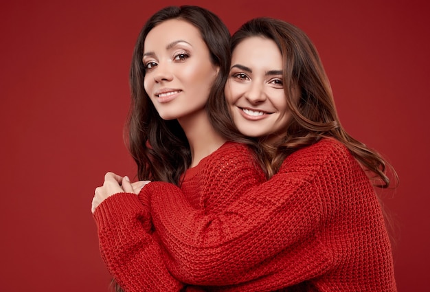 Portrait de deux soeurs assez folles meilleurs amis jumeaux à la mode chandail d'hiver confortable posant