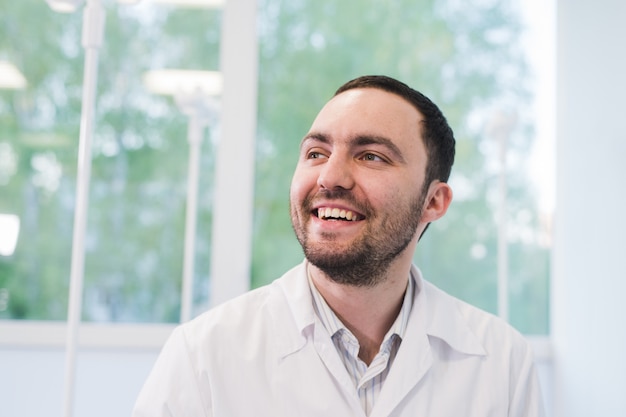 Portrait de docteur heureux à l'hôpital contre la fenêtre