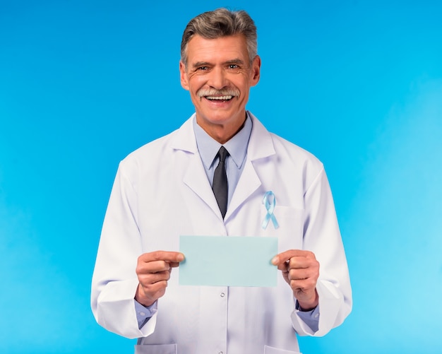 Portrait d'un docteur avec un ruban bleu sur le mur bleu.